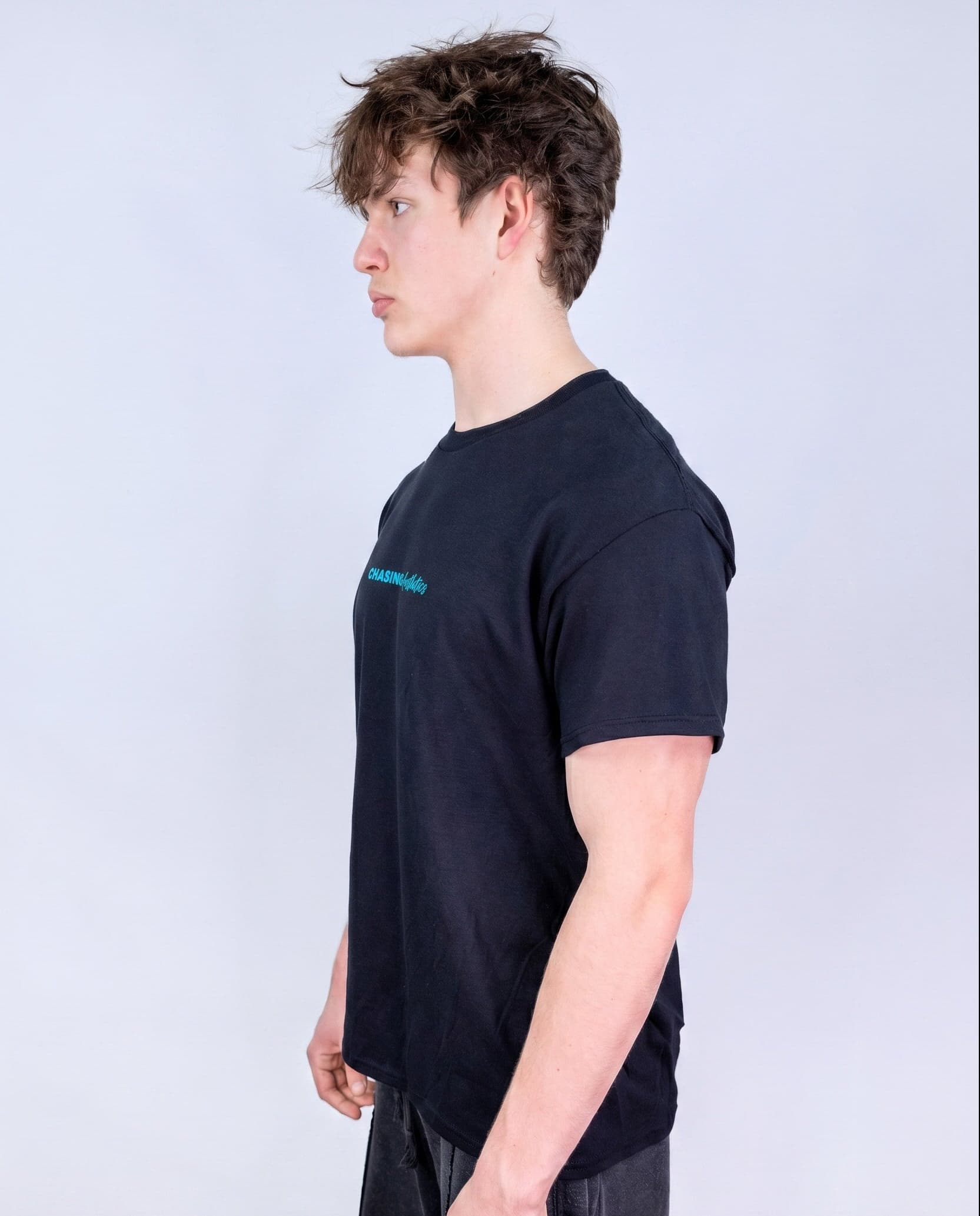 Person wearing a black t-shirt with a logo on a light gray background