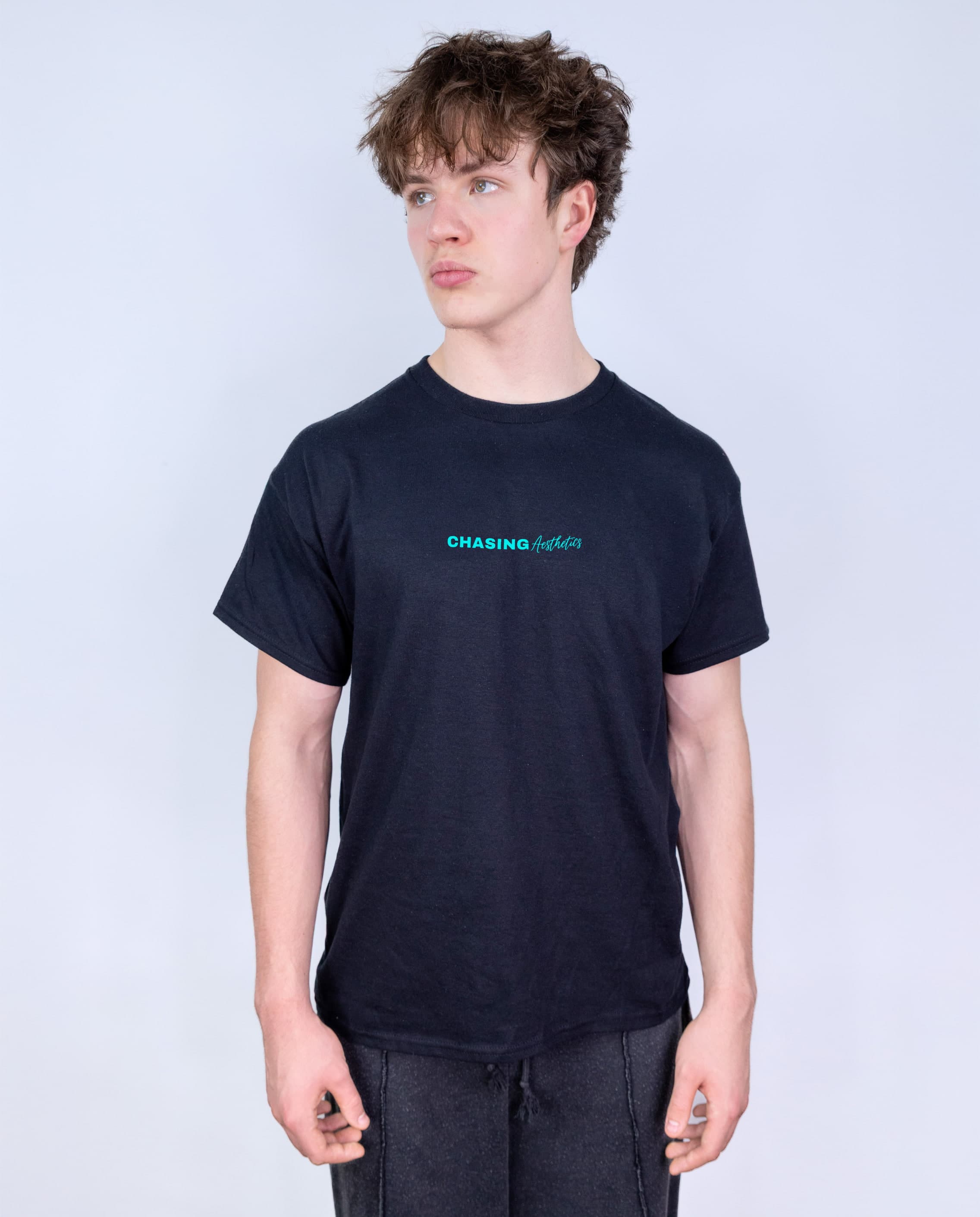 Person wearing a black t-shirt with 'Chasing Aesthetics' text on a white background