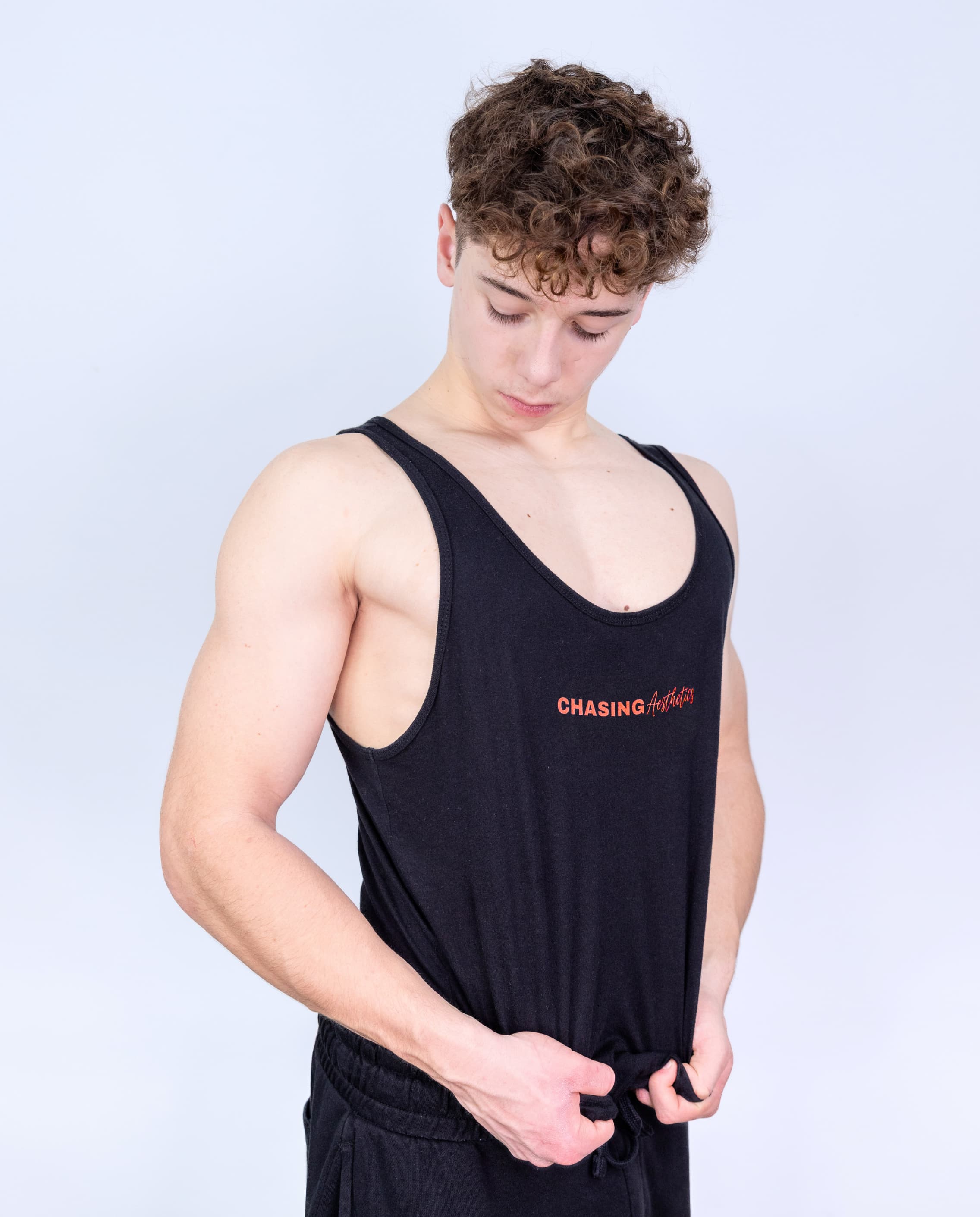Person wearing a black tank top with 'Chasing Aesthetics' text on a light gray background